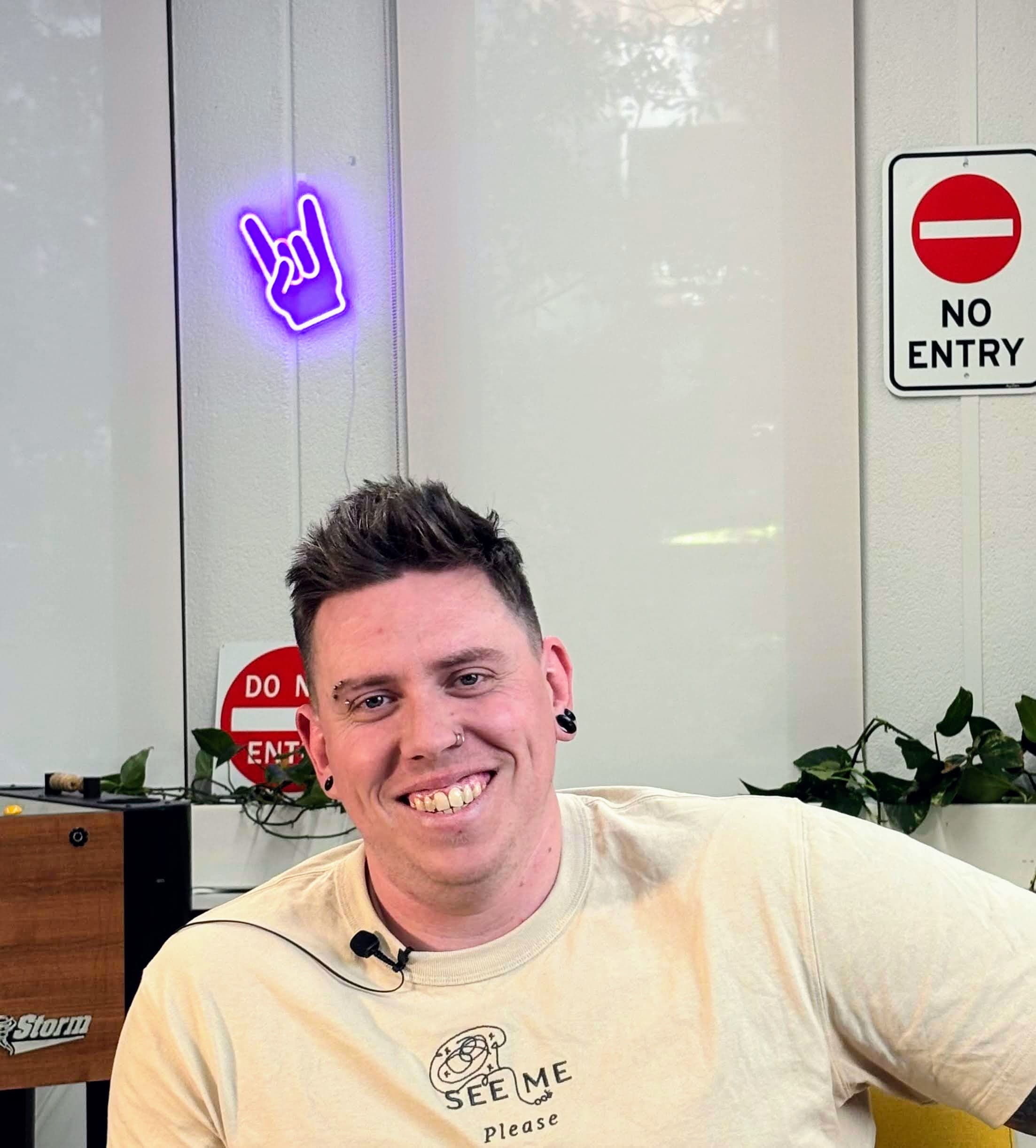 Photo of Dan smiling. he has two nose rings but looks approachable and like a happy dude